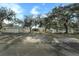 Inviting exterior view of this charming home featuring a lush front yard, a fenced in yard, and mature trees with a storage unit at 15040 Ne 248Th Avenue Rd, Fort Mc Coy, FL 32134