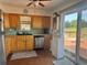 Traditional kitchen with ample wood cabinetry, stainless steel dishwasher, and a sunny window overlooking the deck at 15040 Ne 248Th Avenue Rd, Fort Mc Coy, FL 32134