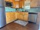 Well-lit kitchen featuring stainless steel appliances, wood cabinets, and tile backsplash, creating a functional cooking space at 15040 Ne 248Th Avenue Rd, Fort Mc Coy, FL 32134