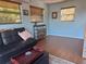 Cozy living room with blue walls, wood-look floors, multiple windows, and modern comforts at 15040 Ne 248Th Avenue Rd, Fort Mc Coy, FL 32134