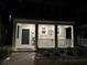Well-lit house exterior at night, featuring a front porch with rocking chairs and a landscaped walkway at 1563 Cross Prairie Pkwy, Kissimmee, FL 34744