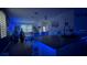 Open concept kitchen with island, white cabinets, and blue accent lighting at 1563 Cross Prairie Pkwy, Kissimmee, FL 34744