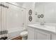Cozy bathroom features tub shower combo, decorative botanicals, and modern white vanity at 1609 Hill Park Dr, Deltona, FL 32725