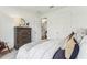 Bright bedroom featuring a wooden dresser, bedside lamps, and views to the hallway at 1609 Hill Park Dr, Deltona, FL 32725