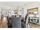 Dining room with wooden floors, a round table, decorative mirror, and access to the kitchen at 1609 Hill Park Dr, Deltona, FL 32725