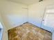 A bright, vacant room with white walls, tan tiled floors, and a closet with white folding doors at 2101 La Due Ct, Orlando, FL 32811