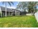 Large backyard with lush lawn, screened patio, and privacy fencing at 231 Chestnut Ridge St, Winter Springs, FL 32708