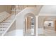 Grand foyer featuring marble floors, staircase, and archway. A glimpse of the pool is seen through the door at 231 Chestnut Ridge St, Winter Springs, FL 32708