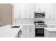 Kitchen featuring stainless steel appliances, white cabinets, quartz countertops, and modern fixtures at 231 Chestnut Ridge St, Winter Springs, FL 32708