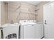 Well-equipped laundry room with utility sink, washer, dryer, and shelving at 231 Chestnut Ridge St, Winter Springs, FL 32708