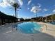 Resort-style pool with clear blue water, lounge chairs, and palm trees under a sunny sky at 2328 Midtown Ter # 1024, Orlando, FL 32839