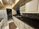 Kitchen with stainless sink, mosaic backsplash, white cabinets, and direct access to the laundry area at 2328 Midtown Ter # 1024, Orlando, FL 32839