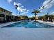 Sparkling swimming pool surrounded by palm trees, umbrellas, and lounge chairs, perfect for relaxation at 2328 Midtown Ter # 1024, Orlando, FL 32839