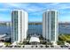 An aerial view of the two white highrise condo towers on the water with a parking garage in front at 241 Riverside Dr # 201, Daytona Beach, FL 32117