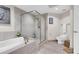 Bright bathroom featuring a large bathtub with a seamless glass shower and neutral-colored tile at 241 Riverside Dr # 201, Daytona Beach, FL 32117