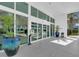 Building entrance featuring modern glass doors and manicured plants in pots at 241 Riverside Dr # 201, Daytona Beach, FL 32117