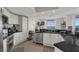 Bright kitchen featuring white cabinets, stainless steel appliances, black granite countertops, and a large window with water views at 241 Riverside Dr # 201, Daytona Beach, FL 32117