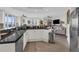Modern kitchen with black granite counters, white cabinets, stainless steel appliances, and adjacent living space at 241 Riverside Dr # 201, Daytona Beach, FL 32117