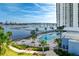 A nice community pool with lounge chairs and palm trees with a view of the bay and nearby bridge at 241 Riverside Dr # 201, Daytona Beach, FL 32117
