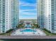 Aerial view of the community pool and entrance to the condos with palm trees and ample seating at 241 Riverside Dr # 201, Daytona Beach, FL 32117