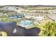 Expansive aerial view showcasing a community clubhouse, pool, tennis courts, and scenic lakes at 2496 Pine Preserve Ct, St Cloud, FL 34771