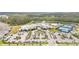 Stunning aerial view of a modern community clubhouse, pool, and tennis courts surrounded by lush landscaping at 2496 Pine Preserve Ct, St Cloud, FL 34771