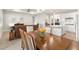 Open-concept dining area with table and chairs, connecting the living room and white kitchen at 2496 Pine Preserve Ct, St Cloud, FL 34771