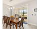 Dining room with wood table and chairs, sliding door to screened lanai with pond view at 2496 Pine Preserve Ct, St Cloud, FL 34771