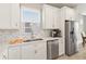 The kitchen offers white cabinetry, a stainless steel refrigerator and a great view from the sink window at 2496 Pine Preserve Ct, St Cloud, FL 34771