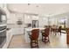 Bright, open kitchen with white cabinets, marble backsplash, island with seating, and stainless steel appliances at 2496 Pine Preserve Ct, St Cloud, FL 34771