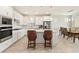 The open concept kitchen has a large island, white cabinets, stainless steel appliances, and ample natural light at 2496 Pine Preserve Ct, St Cloud, FL 34771