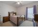 Cozy bedroom features a wood-finished bed frame, a ceiling fan, and large windows at 253 Golden Sands Cir, Davenport, FL 33837