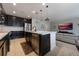 Open kitchen with dark cabinetry, stainless steel appliances, island with bar, and adjacent living area at 253 Golden Sands Cir, Davenport, FL 33837