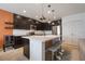 Modern kitchen boasts dark cabinets, stainless steel appliances, and a center island with bar seating at 253 Golden Sands Cir, Davenport, FL 33837