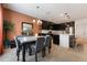 Open-concept kitchen with dark cabinets, stainless appliances, island seating and a dining area at 253 Golden Sands Cir, Davenport, FL 33837
