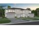 Two-story townhome with gray siding, three-car garage, and landscaping at 2582 Winsome Way, Davenport, FL 33896
