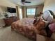 Comfortable bedroom features neutral walls, balcony access, and tropical patterned bedding at 3501 S Atlantic Ave # 6060, New Smyrna Beach, FL 32169