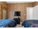 Twin bedroom with brick accent wall and TV at 4285 Prologue Way, Kissimmee, FL 34746