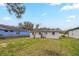 View of the backyard features a grassy lawn and the rear exterior of the home at 451 Rogers St, Orlando, FL 32811