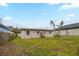 Spacious backyard features a grassy lawn, trees, and the rear of the home at 451 Rogers St, Orlando, FL 32811