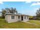 Charming single-story home showcasing a well-maintained lawn, neutral-colored exterior, and brick window trim at 451 Rogers St, Orlando, FL 32811