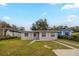 Inviting single-story house featuring a neatly kept front lawn and a light-colored facade with white window accents at 451 Rogers St, Orlando, FL 32811