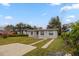 Quaint one-story home with a spacious front yard, long driveway, and classic window designs at 451 Rogers St, Orlando, FL 32811