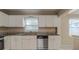 Well-lit kitchen with stainless steel dishwasher, granite counters, white cabinets, and ample storage at 451 Rogers St, Orlando, FL 32811