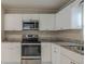 Modern kitchen featuring stainless steel appliances, including a microwave and oven, paired with granite countertops at 451 Rogers St, Orlando, FL 32811