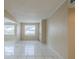 Bright living room with neutral walls, light-colored tile floors, and an open layout leading to the front door at 451 Rogers St, Orlando, FL 32811