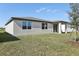 Exterior of the home in a grassy backyard, with windows, sliding doors, and a covered entryway at 4543 Sidesaddle Trl, St Cloud, FL 34772