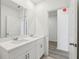 Bright bathroom featuring a double sink vanity with modern chrome faucets, and a doorway to another room at 4543 Sidesaddle Trl, St Cloud, FL 34772