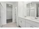 Bathroom featuring double vanity sinks, a glass enclosed shower, and a doorway to a walk in closet at 4543 Sidesaddle Trl, St Cloud, FL 34772