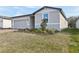 View of a single-story home featuring an attached garage and manicured front yard landscaping at 4543 Sidesaddle Trl, St Cloud, FL 34772
